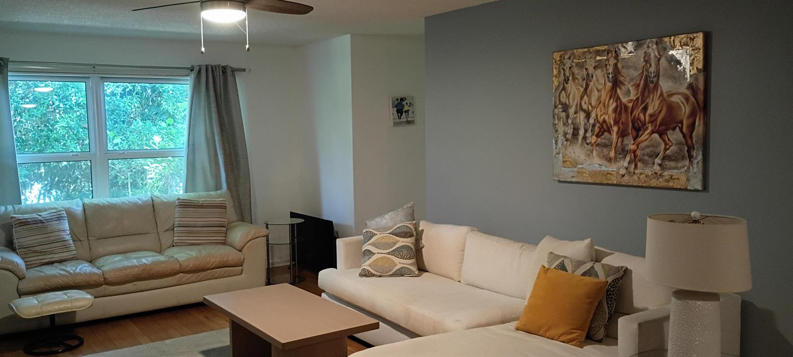 A living room features two white sofas, a coffee table, and a large horse painting — 8387 SE Croft Circle # Q3, Hobe Sound FL 33455, HOBE SOUND, FL