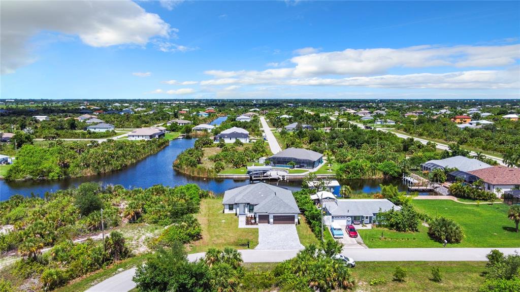 An aerial view shows a residential neighborhood with houses situated along a canal — 14267 MONTMARTE AVENUE, PORT CHARLOTTE, FL
