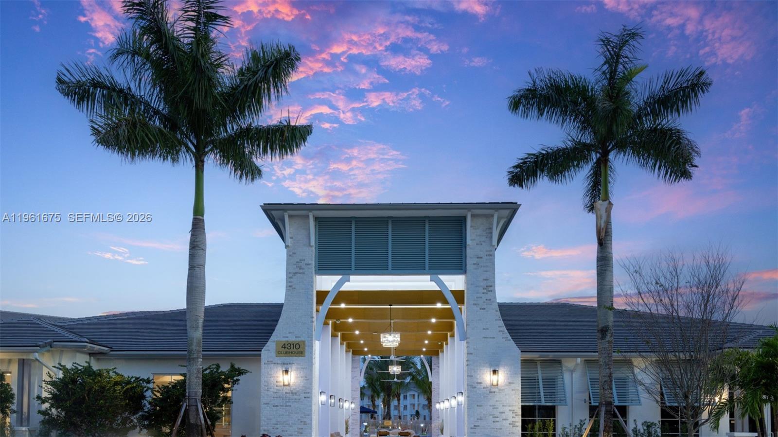 A clubhouse entrance features a white stone archway flanked by two tall palm trees — 4310 Chukka Ln # B1, Lake Worth FL 33467, LAKE WORTH, FL
