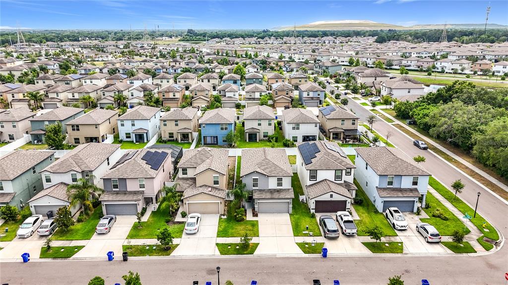 An aerial view shows a suburban neighborhood with rows of houses and parked cars — 7405 EVENING PRIMROSE COURT, TAMPA, FL