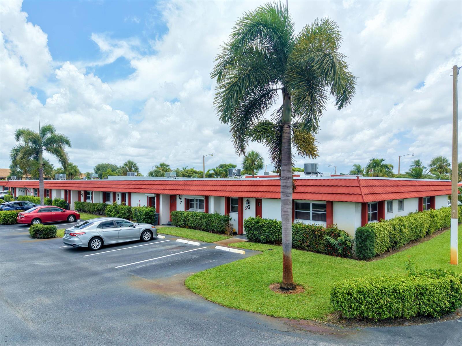 A single-story apartment building with a red tile roof, palm trees, and a parking lot — 5800 W Fernley Dr W # 9, FL 33415, FL