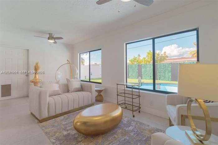 A bright living room features a white sofa, gold coffee table, and a pool view — 8531 NW 25th St, Sunrise FL 33322, SUNRISE, FL
