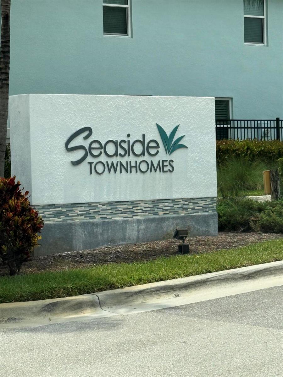 A white monument sign with the text Seaside Townhomes stands in front of a building — 342 SE Angler Drive, Stuart FL 34994, STUART, FL