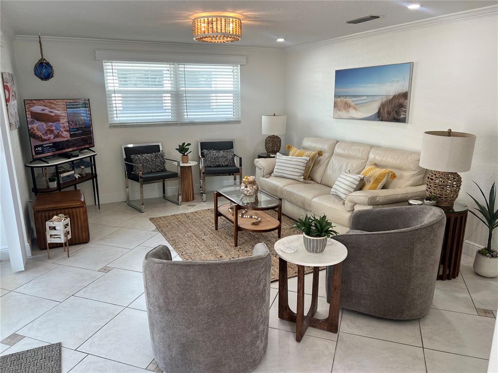 A living room features a beige sofa, two grey armchairs, and a glass coffee table — 6154 MIDNIGHT PASS ROAD UNIT B16, SARASOTA, FL