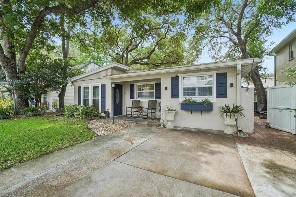 A single-story house with a concrete driveway, blue shutters, and a small front porch — 3218 W OAKELLAR AVENUE, TAMPA, FL