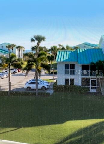 An exterior view of a multi-story building with a teal roof and surrounding palm trees — 2400 S OCEAN DRIVE UNIT 5331, FORT PIERCE, FL