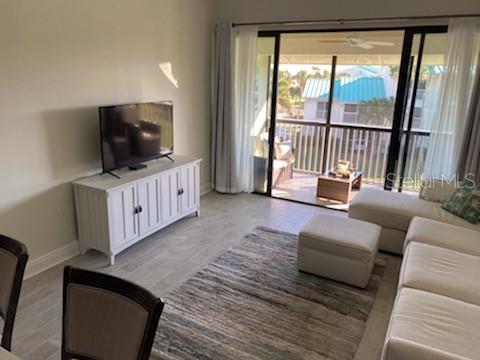 A living room features a white media console, a television, and a sectional sofa — 2400 S OCEAN DRIVE UNIT 5331, FORT PIERCE, FL