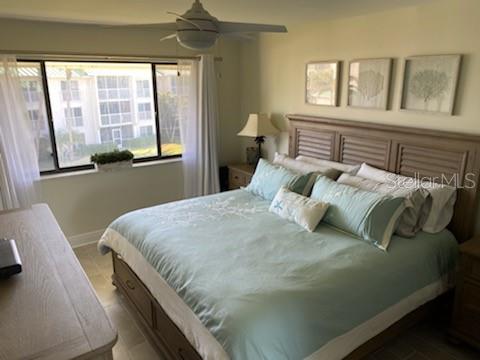 A bedroom features a king bed with light blue bedding, a ceiling fan, and large windows — 2400 S OCEAN DRIVE UNIT 5331, FORT PIERCE, FL