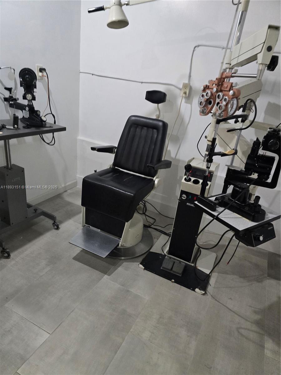 This room contains an optometry examination chair and specialized eye testing equipment — 2100 Coral Way, Coral Gables FL 33145, CORAL GABLES, FL