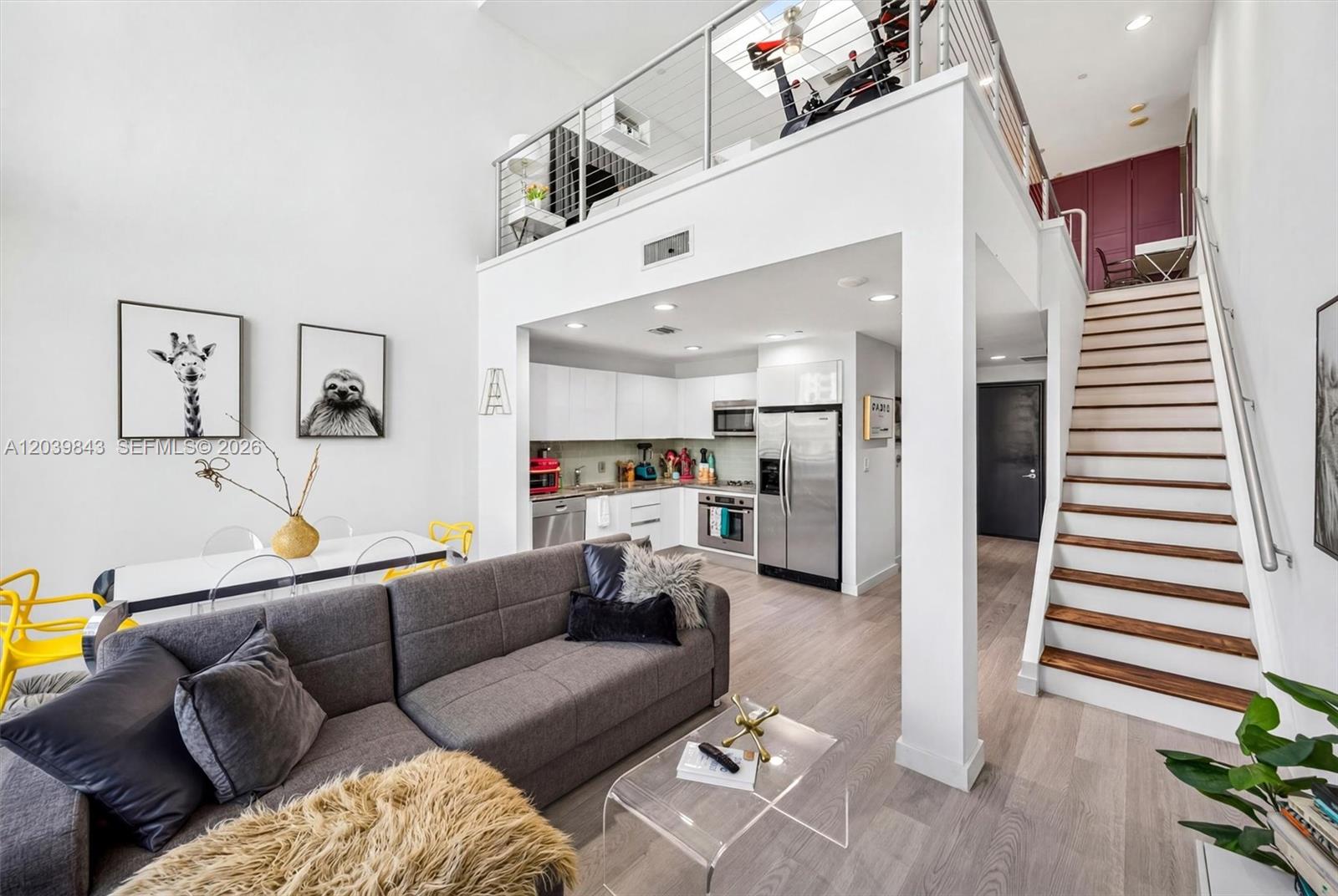 A modern loft apartment features a kitchen, living area, and stairs leading to a mezzanine — 1050 Brickell Ave # 420, Miami FL 33131, MIAMI, FL