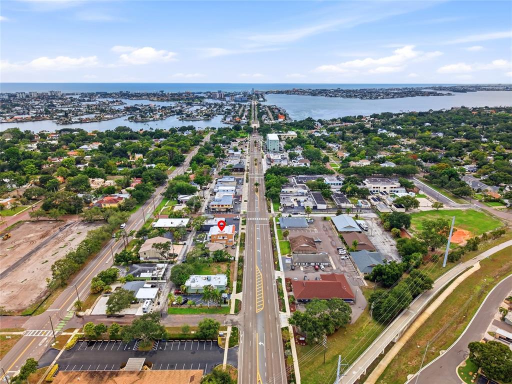 An aerial view shows a multi-story building marked with a red pin along a road — 7024 CENTRAL AVENUE, ST PETERSBURG, FL