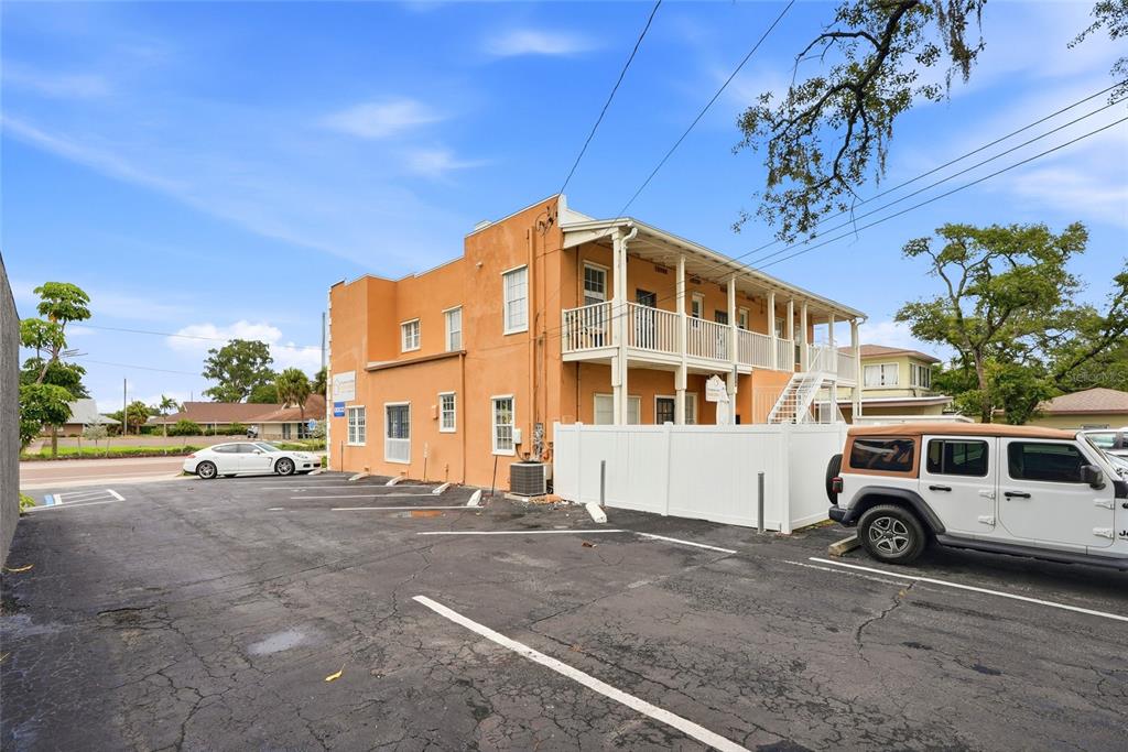 An exterior view of a two-story orange building with a balcony and a parking lot — 7024 CENTRAL AVENUE, ST PETERSBURG, FL