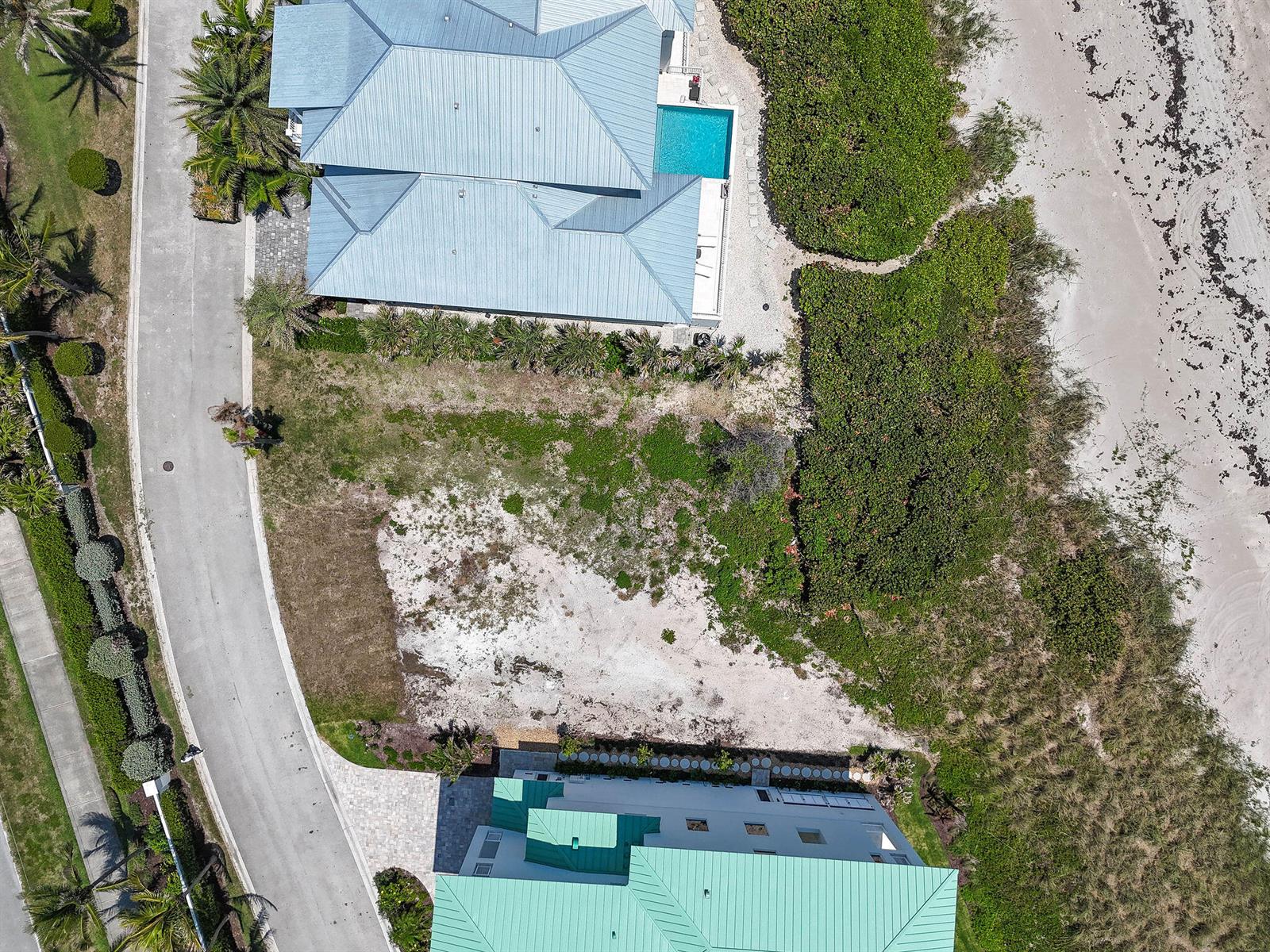 Aerial view of two coastal houses separated by a vacant sandy lot and vegetation — 8128 S Ocean Drive, Jensen Beach FL 34957, JENSEN BEACH, FL
