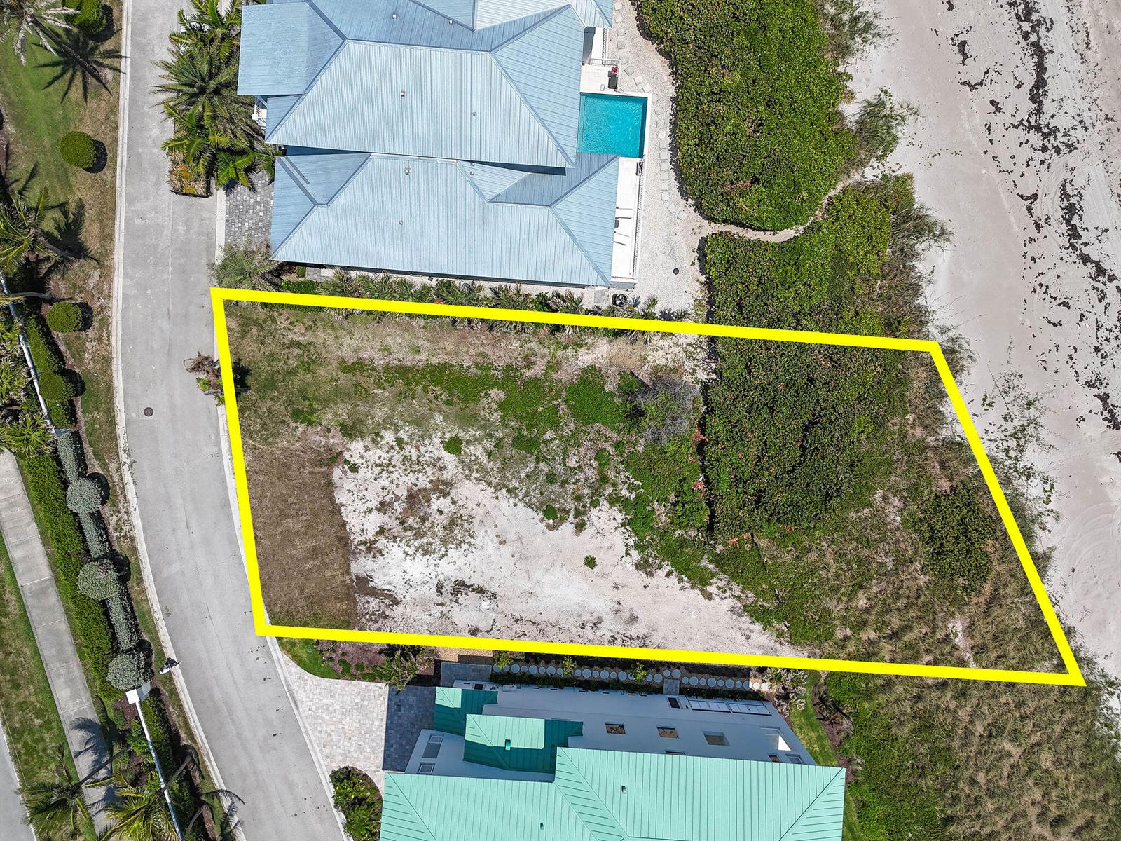 An aerial view shows a vacant, rectangular beachside lot outlined in yellow between two houses — 8128 S Ocean Drive, Jensen Beach FL 34957, JENSEN BEACH, FL