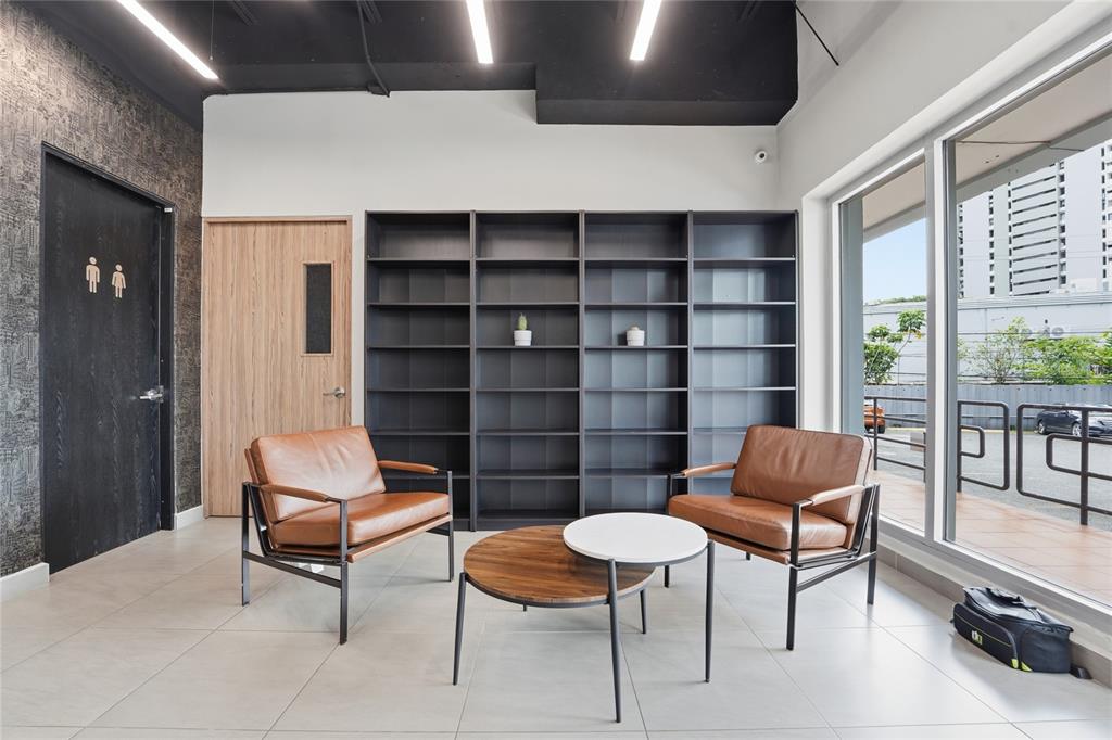 A waiting area features two leather armchairs, a nesting coffee table, and a large bookshelf — 501 CENTRO ALTAMIRA, CALLE PERSEO UNIT 501, SAN JUAN, PR