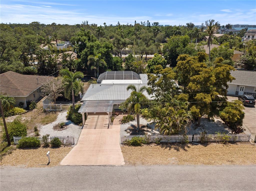 An aerial view of a single-story house with a metal roof and a carport — 7860 HOLIDAY DRIVE, SARASOTA, FL