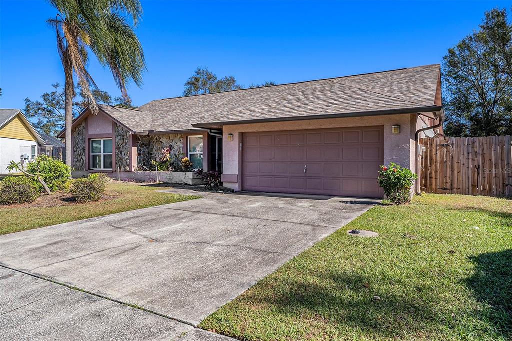 A single-story house with a stone facade, a two-car garage, and a concrete driveway — 1606 DUSTY ROSE LANE, BRANDON, FL
