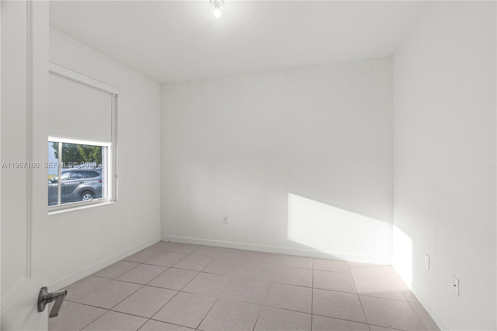 A carpeted staircase leads to an upper level, with a kitchen visible in the background — 12121 NW 23rd Ct, Miami FL 33167, MIAMI, FL