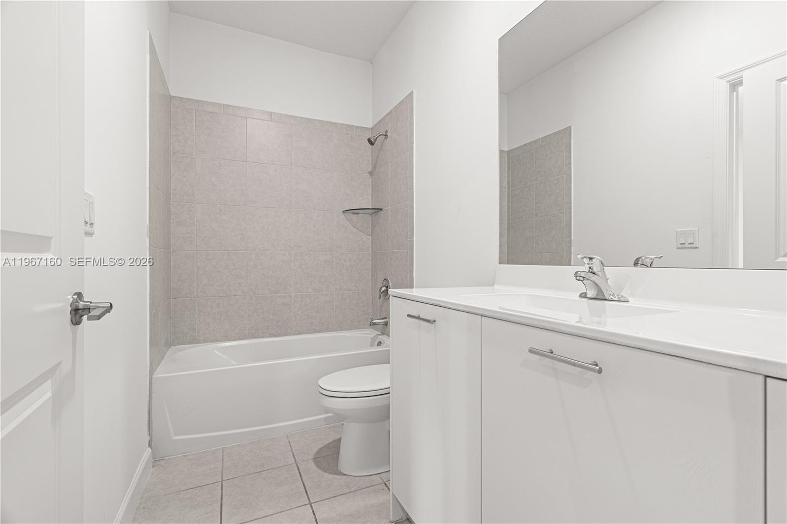 An empty room features white walls, light-colored floor tiles, a window, and a closet — 12121 NW 23rd Ct, Miami FL 33167, MIAMI, FL