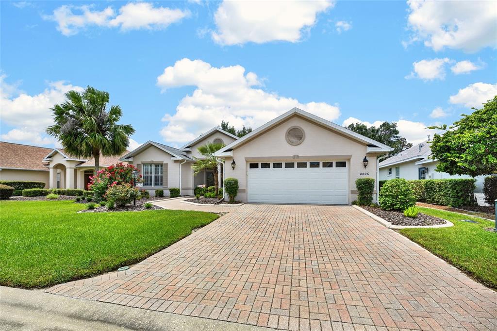A single-story house features a brick paver driveway, a two-car garage, and a manicured lawn — 8806 SW 83RD CIRCLE, OCALA, FL