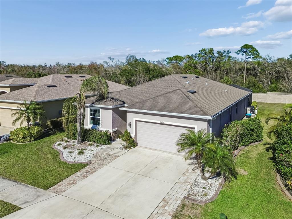 An aerial view of a single-story house with a tan stucco exterior and shingled roof — 7432 47TH AVENUE CIRCLE E, BRADENTON, FL