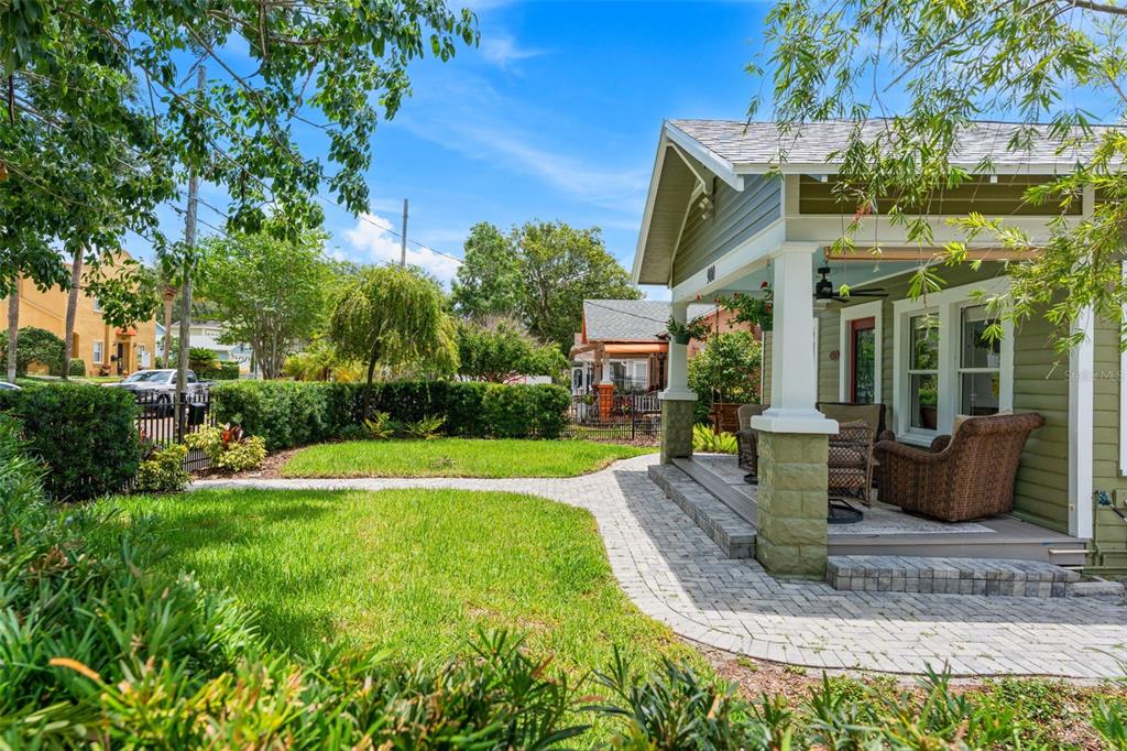 A green house with a covered front porch and a brick paver walkway in Florida — 900 E PINE STREET, ORLANDO, FL