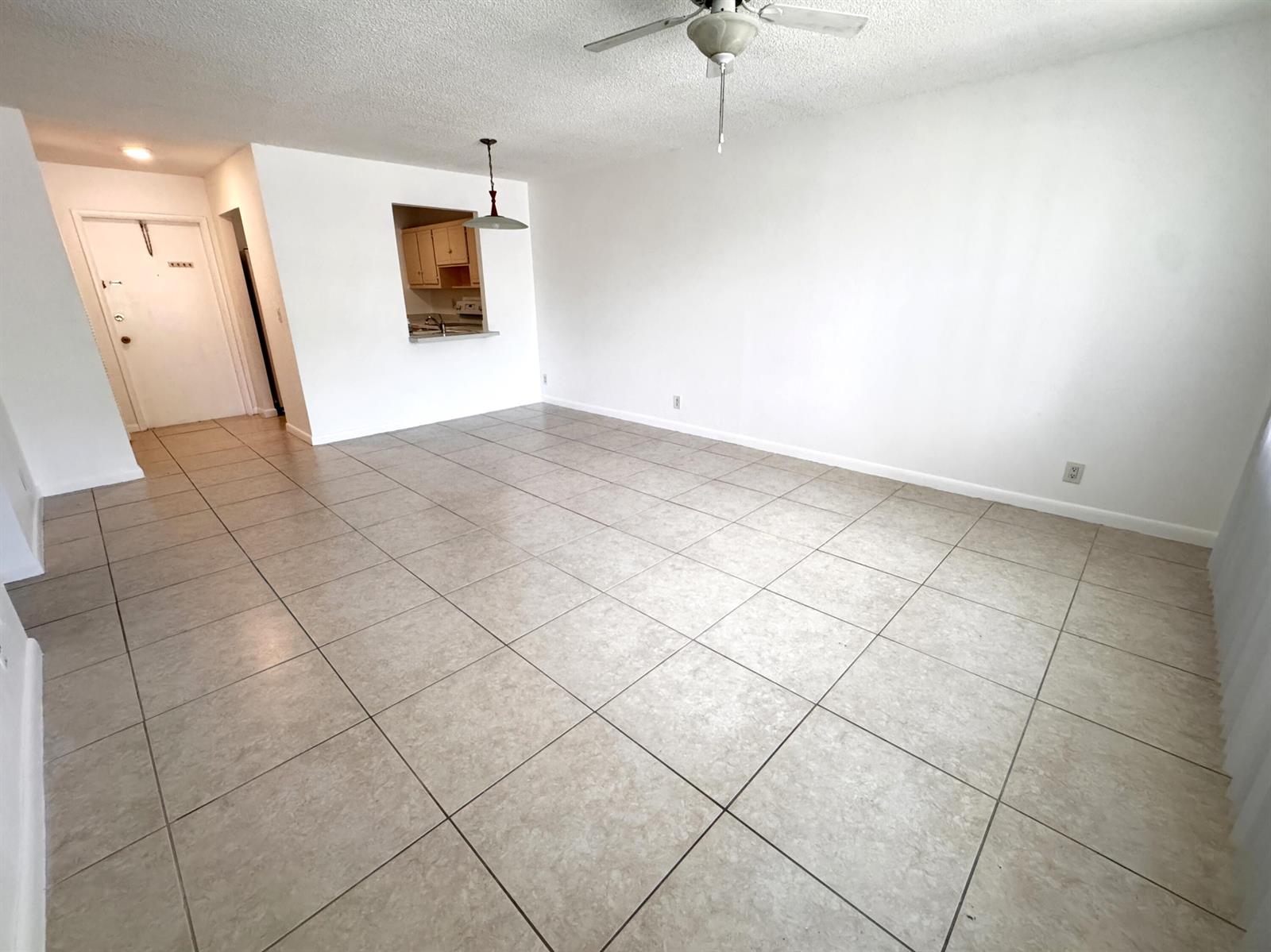 An empty living room features beige tile flooring, white walls, and a ceiling fan — 500 SE 2nd Avenue # 22, Deerfield Beach FL 33441, DEERFIELD BEACH, FL