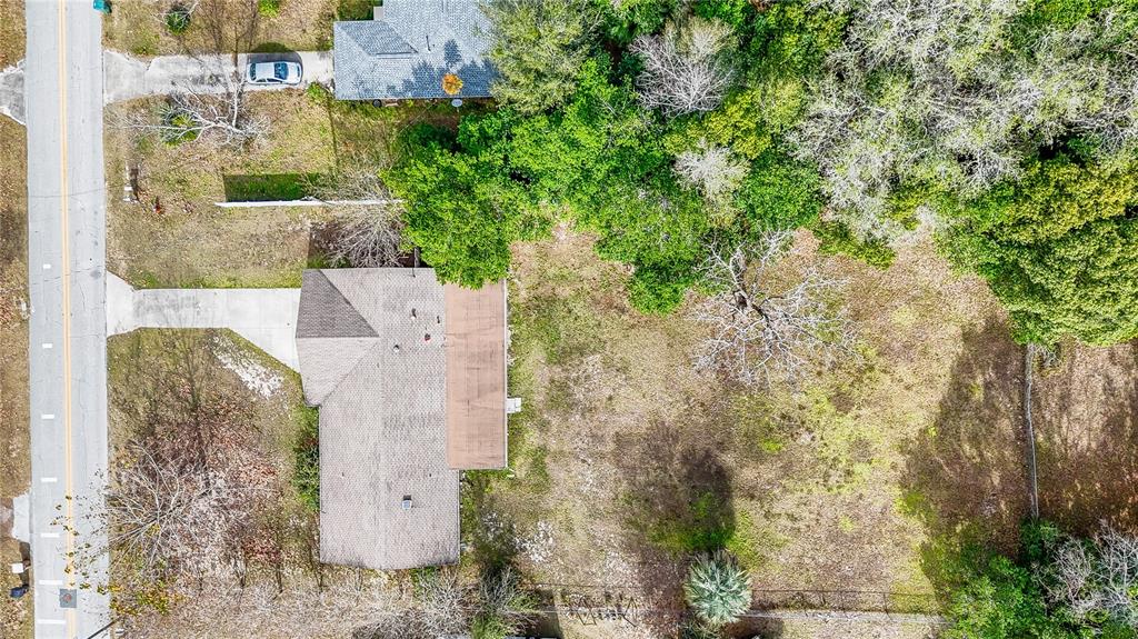 An aerial view shows a house with a large backyard and surrounding trees — 831 NE 41ST AVENUE, OCALA, FL