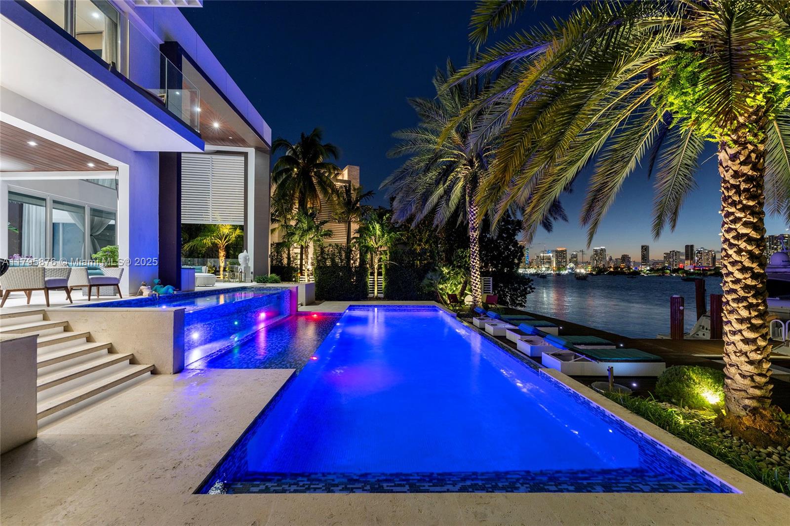 A modern waterfront home features a multi-level illuminated swimming pool and a palm-lined patio — 441 N Hibiscus Dr, Miami Beach FL 33139, MIAMI BEACH, FL