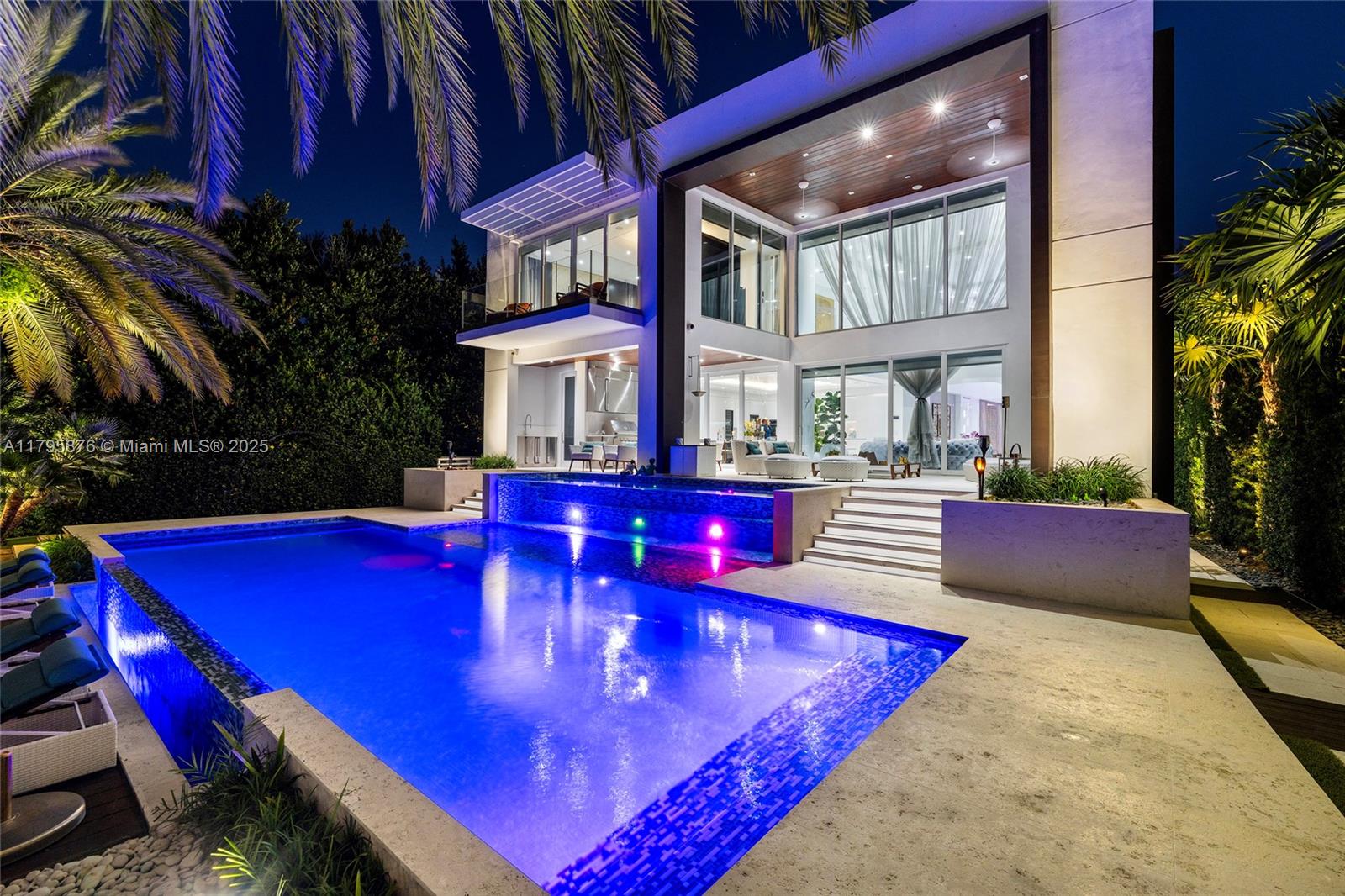 A modern two-story house features a swimming pool with colorful lights at night — 441 N Hibiscus Dr, Miami Beach FL 33139, MIAMI BEACH, FL