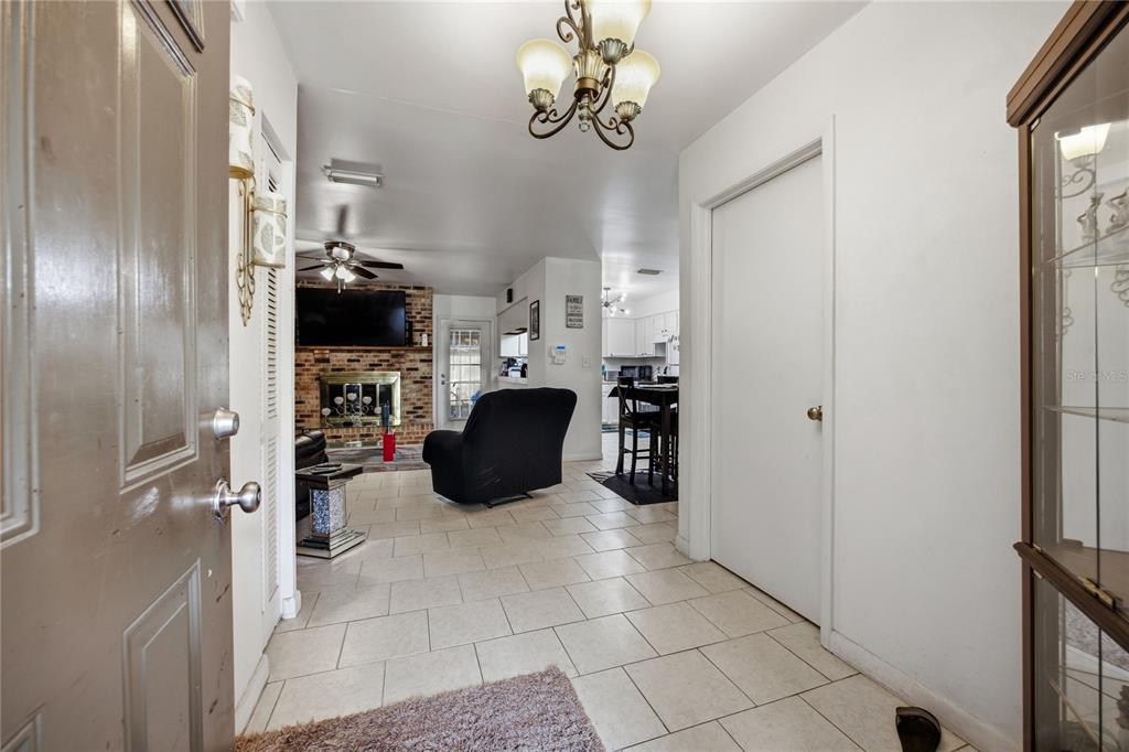 An entryway leads into a living room with a brick fireplace and tiled floors — 7212 SW 18TH PLACE, GAINESVILLE, FL
