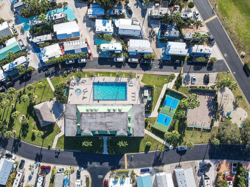 Aerial view of a residential community featuring a swimming pool, tennis courts, and mobile homes — 900 Juno Ocean Walk, Juno Beach FL 33408, JUNO BEACH, FL