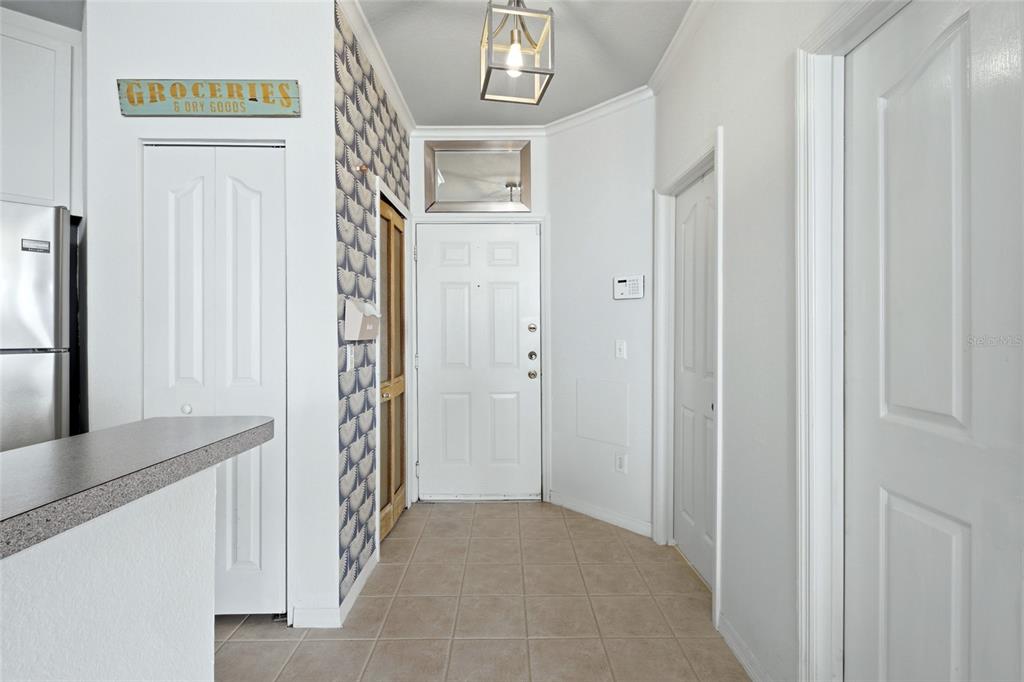 A tiled entryway features a white front door, patterned wallpaper, and a hanging light fixture — 2639 MAITLAND CROSSING WAY UNIT 102, ORLANDO, FL