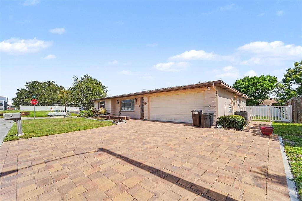 A single-story house with a paved driveway, a two-car garage, and a white fence — 7015 MORAVIAN DRIVE, PORT RICHEY, FL