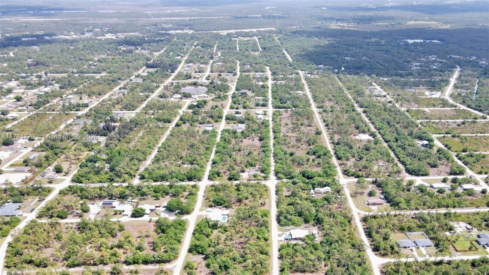 An aerial view shows a rural residential area with scattered houses and dirt roads — 27049 Seeger Dr, Punta Gorda FL 33955, PUNTA GORDA, FL