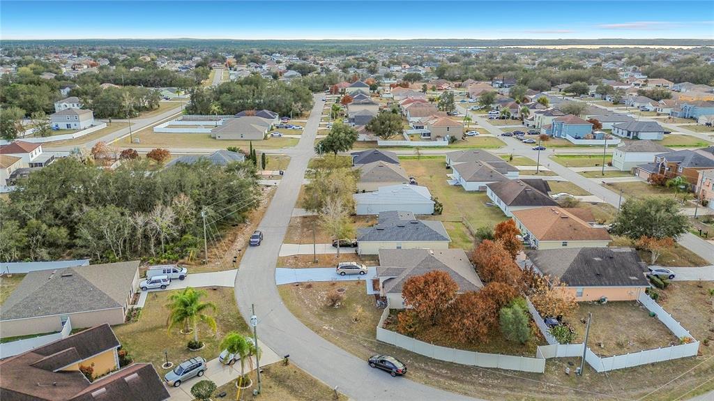 An aerial view shows a suburban neighborhood with houses, driveways, and streets — 1910 DOLPHIN DRIVE, KISSIMMEE, FL