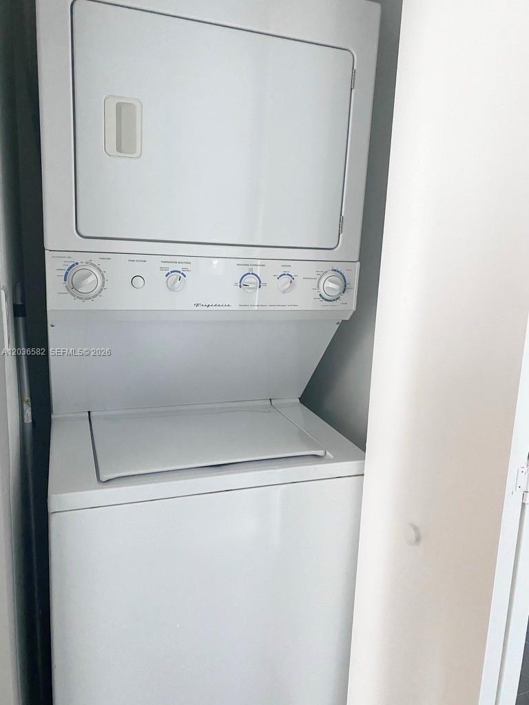 A white Frigidaire stacked washer and dryer unit is installed in a small closet — 335 BISCAYNE BL # 4200, Miami FL 33131, MIAMI, FL