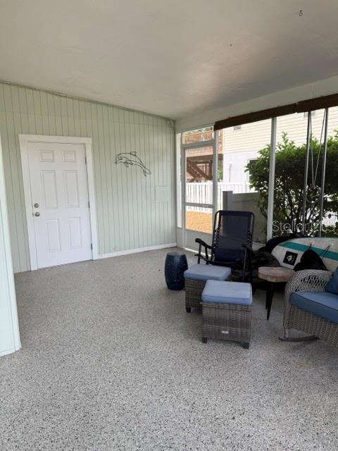 A covered porch features light green vertical siding, a white door, and speckled flooring — 1920 NW 18TH STREET, CRYSTAL RIVER, FL
