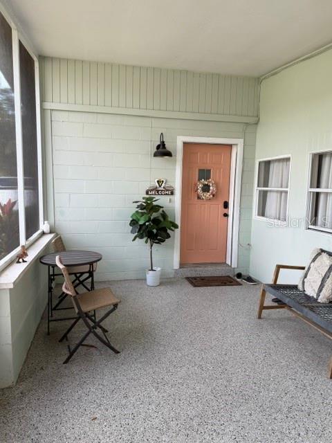 A covered porch features a peach-colored front door, a small bistro set, and a potted plant — 1920 NW 18TH STREET, CRYSTAL RIVER, FL