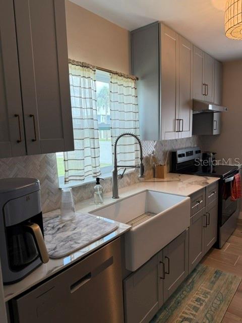 A modern kitchen features gray cabinets, a white farmhouse sink, and a stainless steel faucet — 1920 NW 18TH STREET, CRYSTAL RIVER, FL