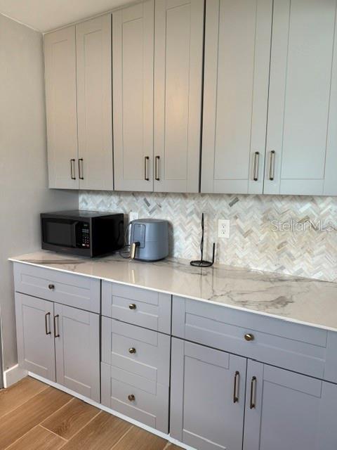A kitchen features gray shaker-style cabinets, a marble-patterned countertop, and a herringbone tile backsplash — 1920 NW 18TH STREET, CRYSTAL RIVER, FL