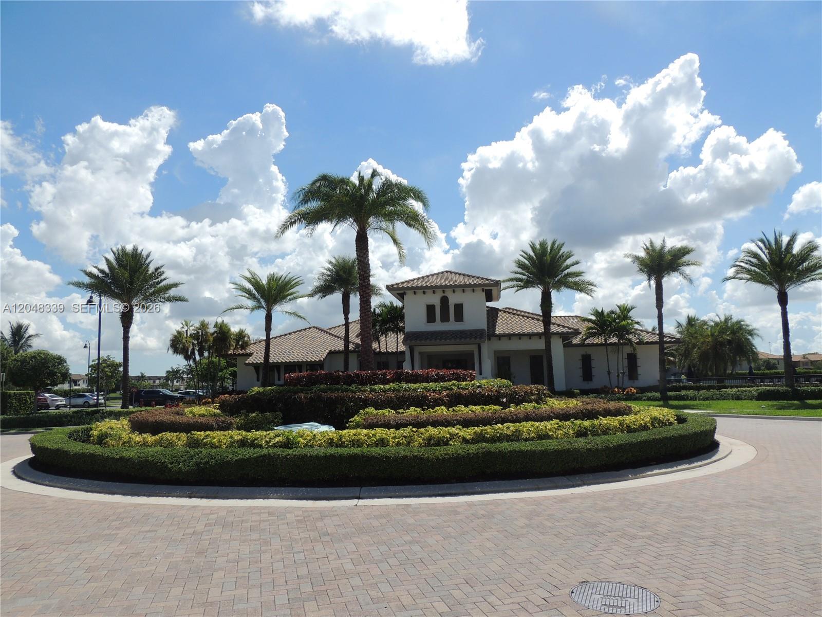 A circular driveway leads to a clubhouse surrounded by manicured hedges and palm trees — 9336 W 34th Ct, Hialeah FL 33018, HIALEAH, FL