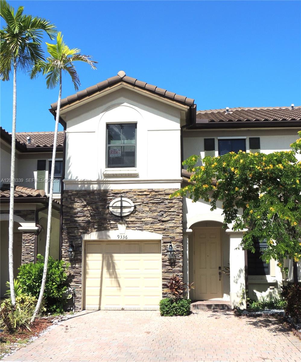 A two-story residential building features a stone-veneer facade, a single-car garage, and a palm tree — 9336 W 34th Ct, Hialeah FL 33018, HIALEAH, FL
