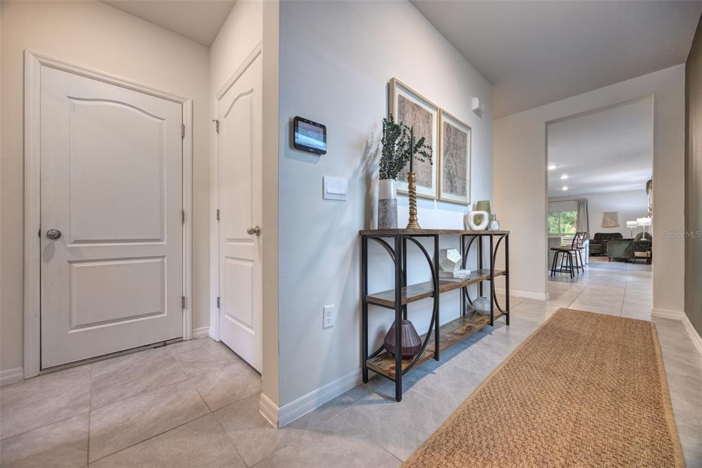 A tiled entryway features a console table, two framed pictures, and a view into a living area — 372 PELHAM PARK DRIVE, DELAND, FL