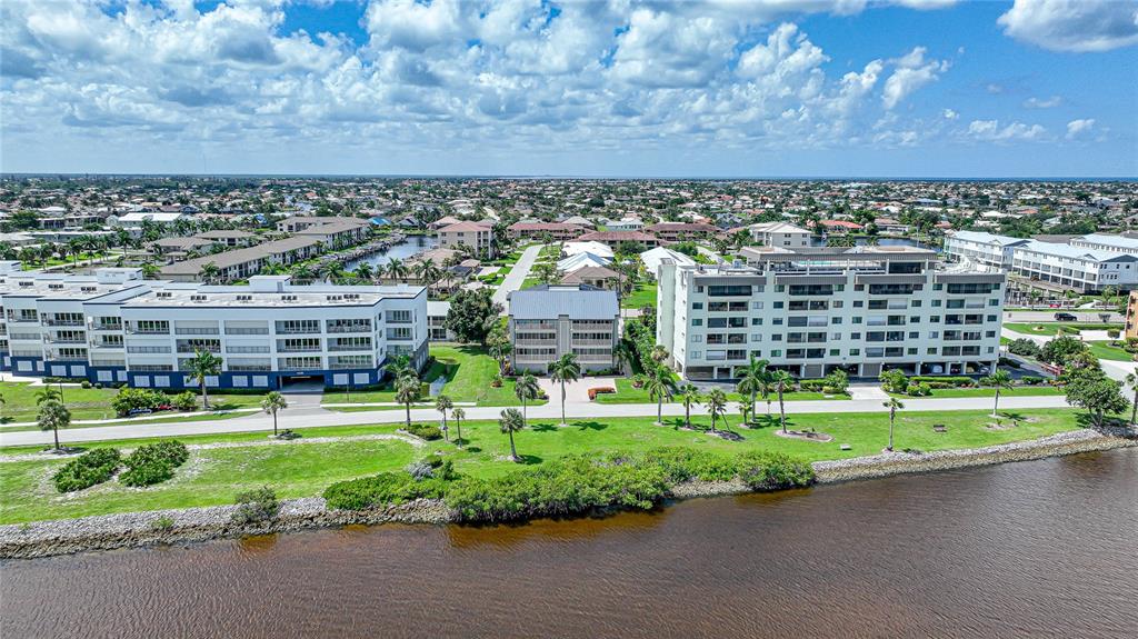 An empty room with light wood flooring, a ceiling fan, and a sliding glass balcony door — 1477 PARK BEACH CIRCLE UNIT 13, PUNTA GORDA, FL
