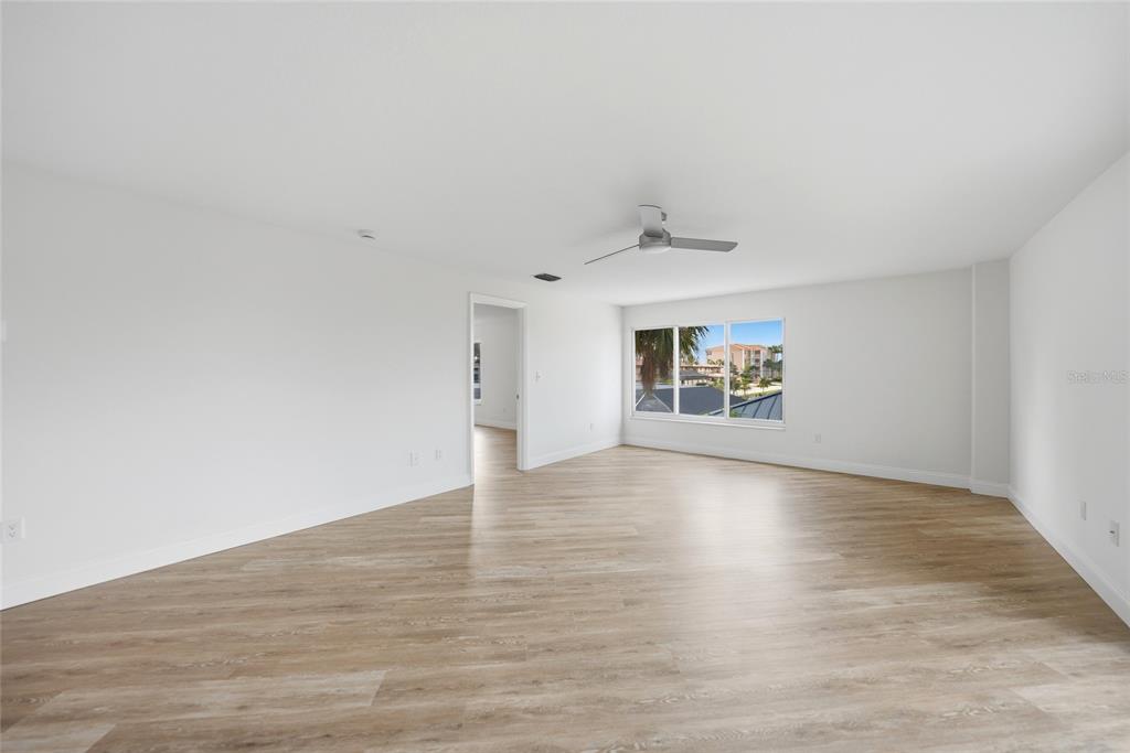A white front door opens into a kitchen with stainless steel appliances and light flooring — 1477 PARK BEACH CIRCLE UNIT 13, PUNTA GORDA, FL