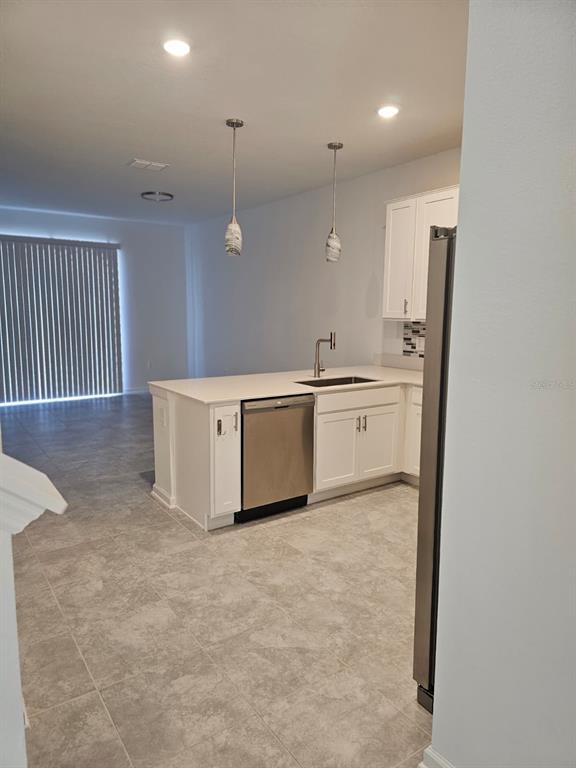 A kitchen features white cabinets, stainless steel appliances, and a central island with a sink — 6063 PEACEFUL PARK WAY, CLERMONT, FL