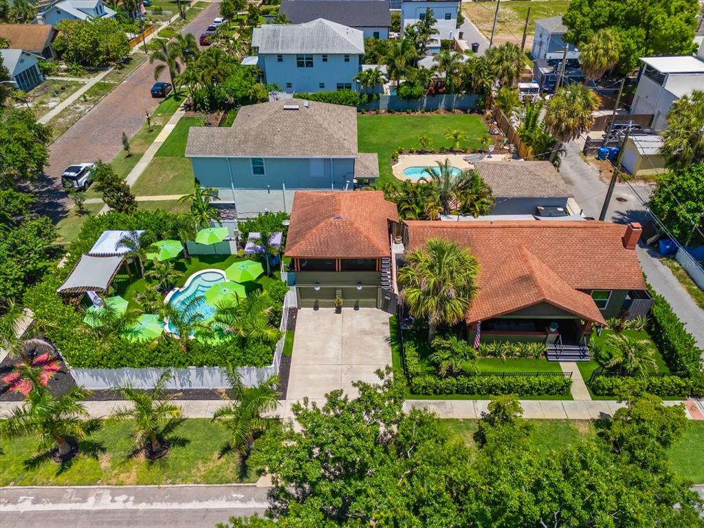 An aerial view shows two adjacent houses with swimming pools, palm trees, and green lawns — 127 23RD STREET N, ST PETERSBURG, FL