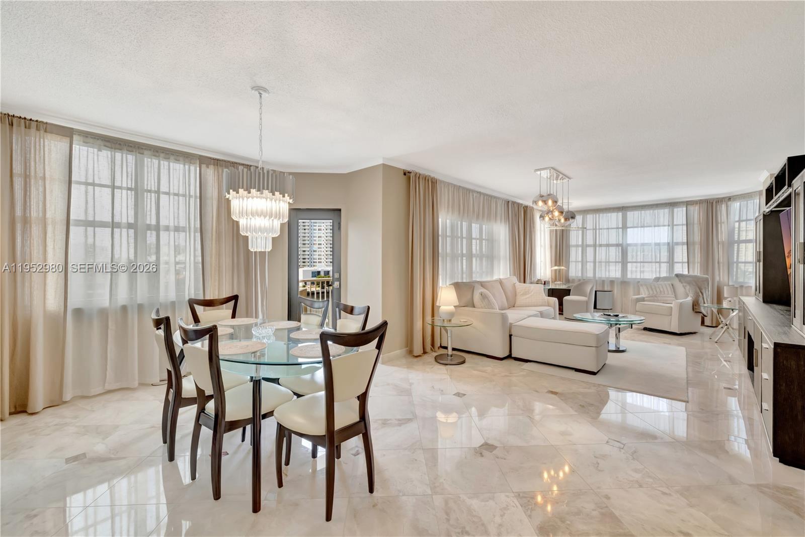 A bright, open-concept living and dining area features marble floors, floor-to-ceiling windows, and modern furniture — 1965 S Ocean Dr # 4S, Hallandale Beach FL 33009, HALLANDALE BEACH, FL