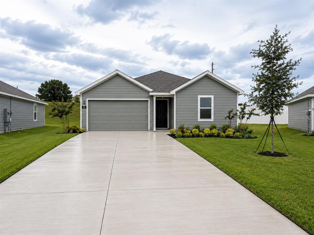 A gray, single-story suburban house features a two-car garage, a concrete driveway, and landscaped lawn — 431 ARTEMIS STREET, LAKE WALES, FL